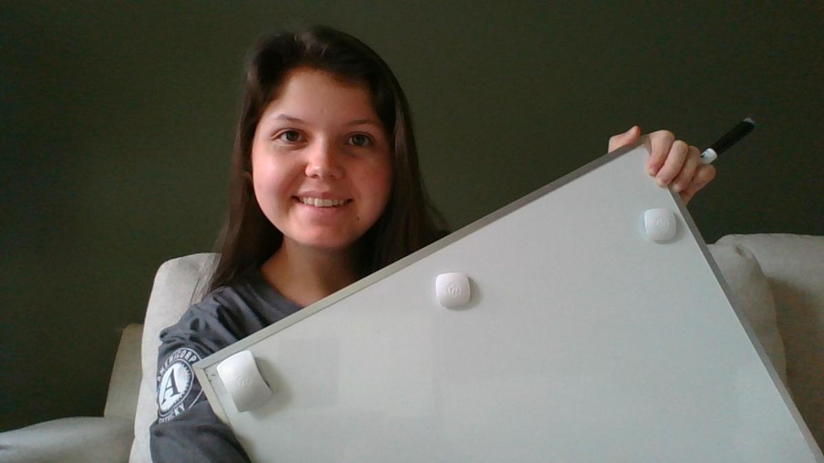 Kathryn holding a whiteboard used to virtually tutor students