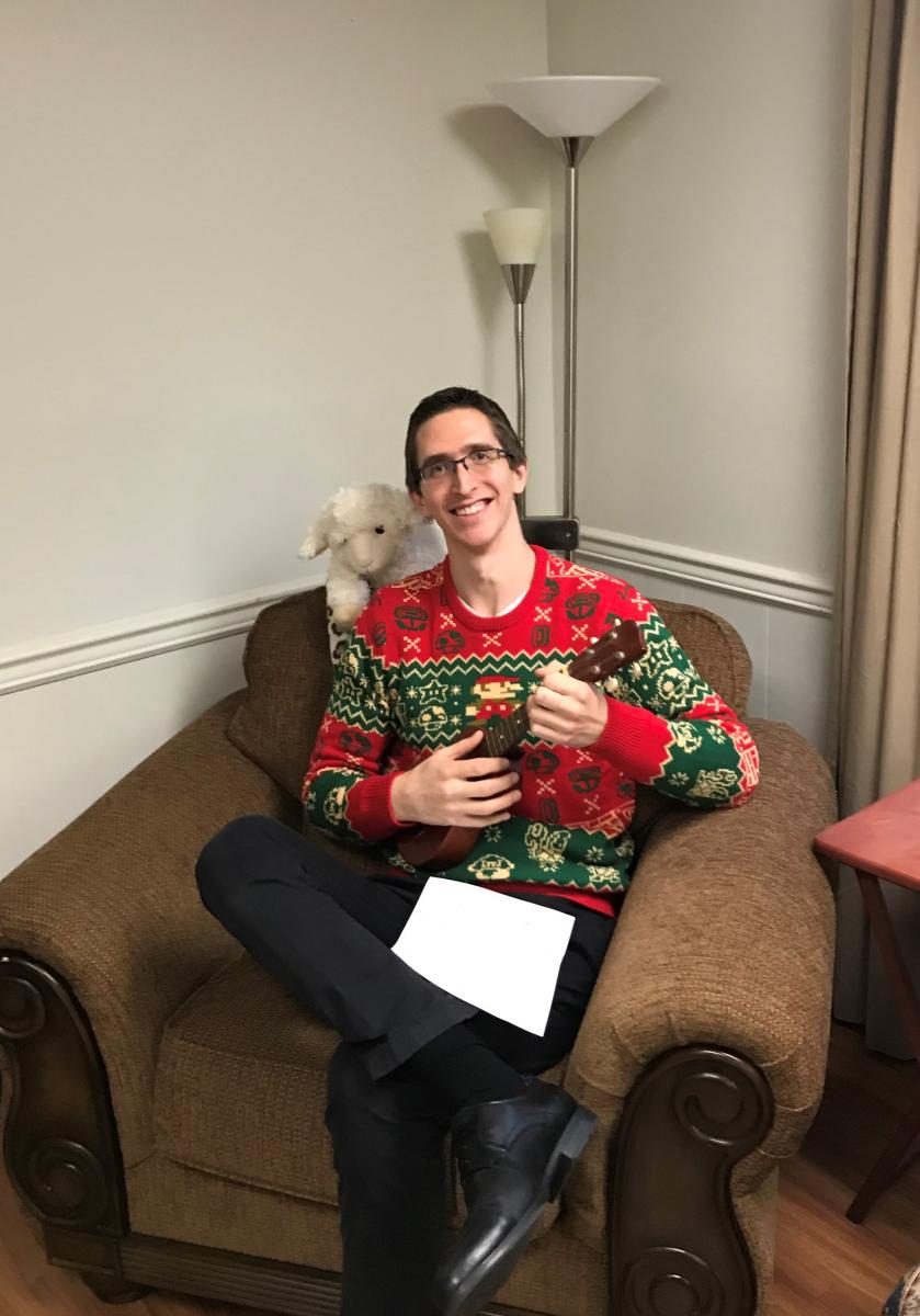 Benny in his Christmas attire, strumming on the ukulele.